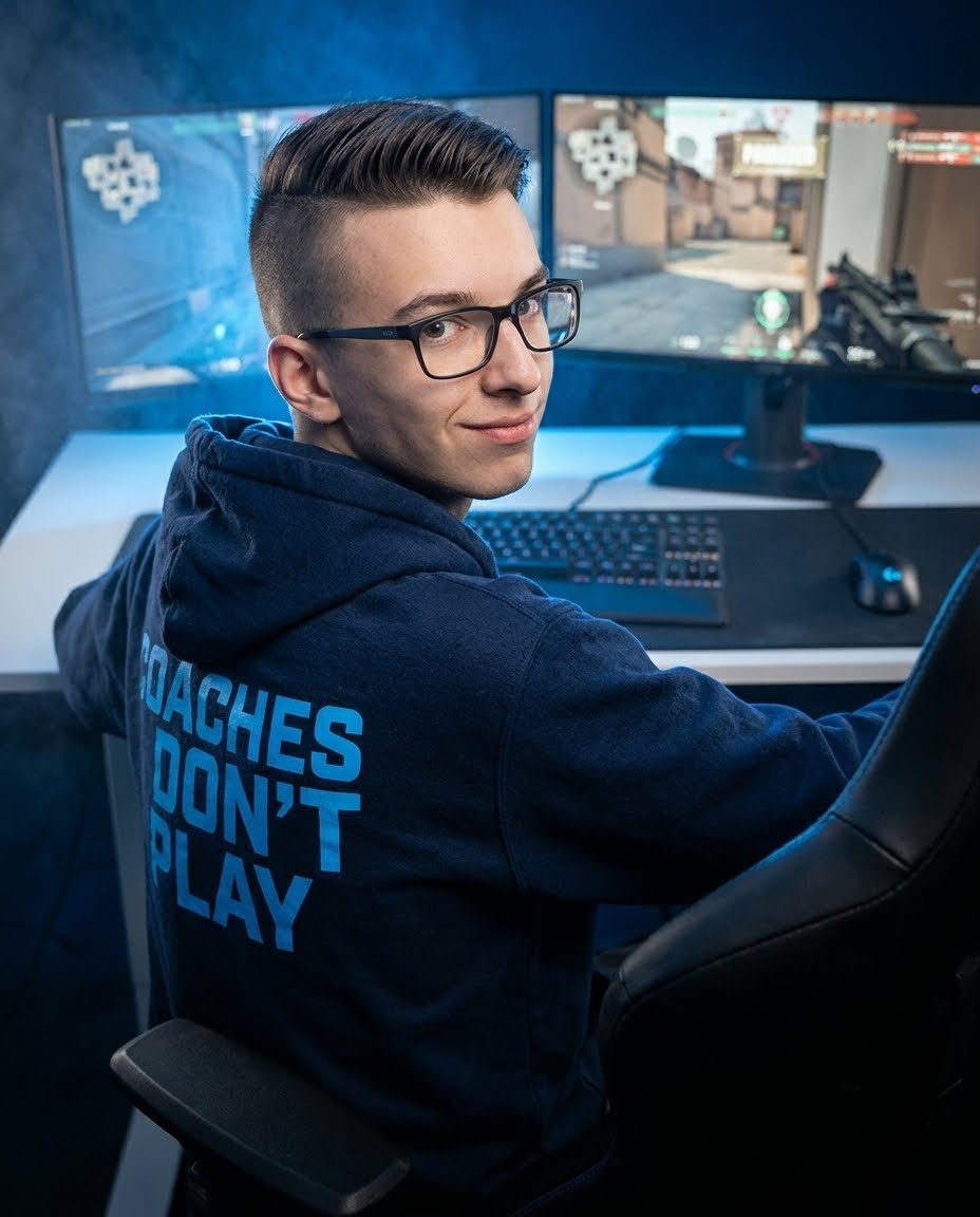 Alex looking over his shoulder in a hoodie printed with Coaches Don't Play